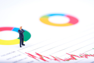 Miniature people:Businessman standing and see the the stock trend with copy space. Financial crisis. Data analysis. Stock market volatility risk. Information for investment. Financial concept