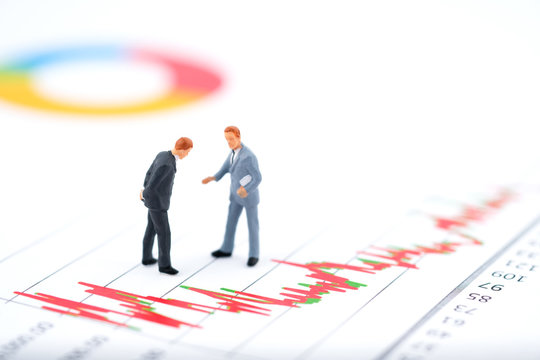 Miniature people:Businessman discuss on the stock trend (increase or decrease) with copy space. Financial crisis. Data analysis. Stock market volatility risk. Information for investment.
