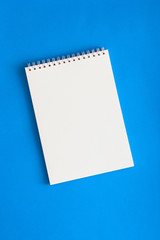 Culinary blank white notebook on a blue background, top view, copy space