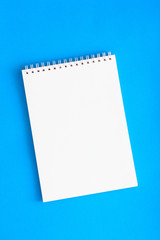 Culinary blank white notebook on a blue background, top view, copy space