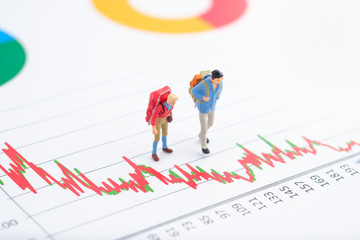 Miniature people:Tourist teams standing on the paper chart. Financial crisis. Data analysis. Stock market volatility risk. Information for investment. Financial concept