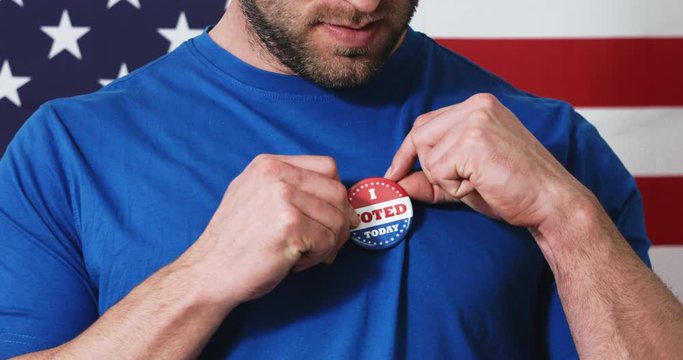 Man putting on I Voted Today button for Presidential election 2020 in America.