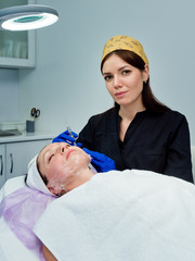 A beautiful girl doctor in is preparing to do a prick of hyaluronic acid for facial rejuvenation procedure.