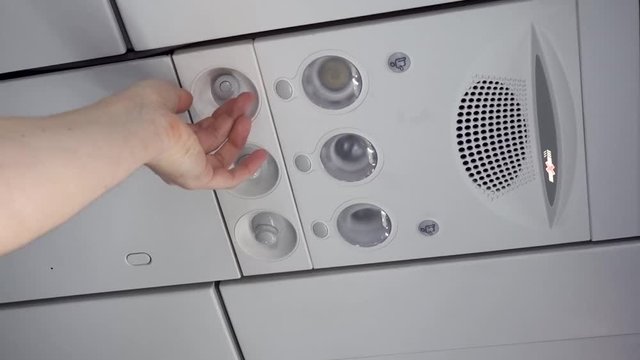 Air conditioning in an airplane. Man adjusts air conditioning in an airplane.