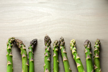 raw green asparagus stems lying in a row