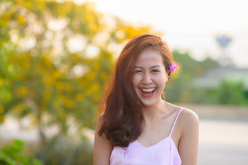 Naklejka premium Portrait of a beautiful asian woman smiling brightly look at the camera. Happy cute model laughing outdoor in park.