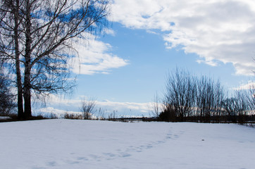 footprints in the snow and blue sky in spring