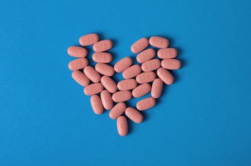 HIV/AIDS therapy pills on pink background.