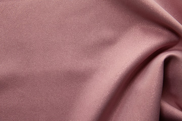 Beautiful fabric of one color is folded on a table in daylight