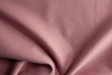 Beautiful fabric of one color is folded on a table in daylight