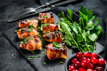 Baked bacon wrapped chicken breast. Black background. Top view