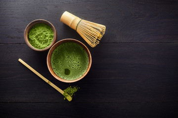 Matcha powder. Organic green matcha tea ceremony. Healthy drink. Traditional japanese drink on black wooden background - obrazy, fototapety, plakaty