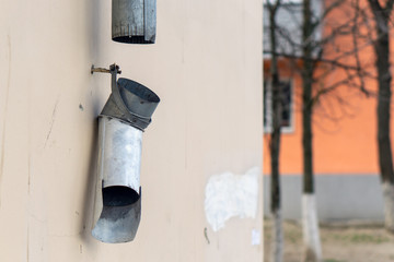 broken downpipe against a wall