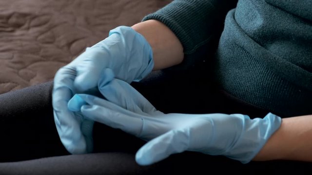 Female doctor takes off his gloves, hands close-up.