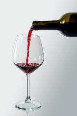 Bottle pouring red wine into an elegant glass