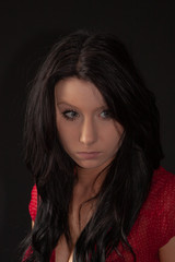 Low key headshot of a young woman in red