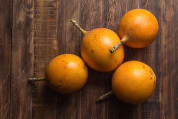 Sweet granadilla or grenadia passion fruit on wooden board. Top view