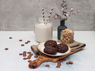 Chocolate chip cookies with glass of milk on gray background