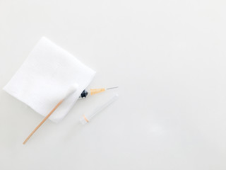 cotton bud or swab on gauze and syringe on white background for medical treament concept with copy space