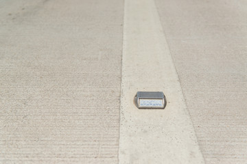 One side a white raised pavement marker used for lane markings.