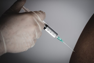 Closeup, doctor with syringe doing injection vaccine,flu,influenza in the shoulder