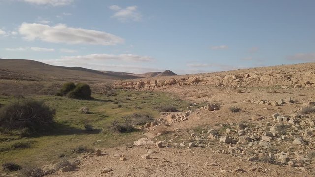 Pan over green part of desert and dry part. Shows water flow in valley