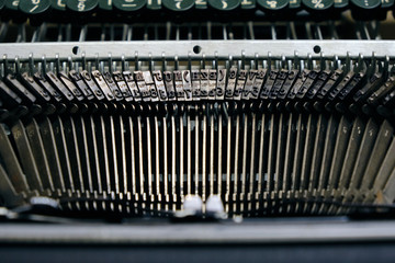 Mechanism of typesetting strikers with the English alphabet in an old retro typewriter.