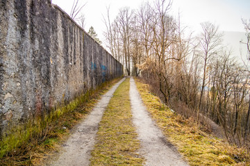 Dirt path along a high wall