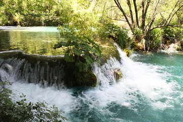 Small waterfall, water threshold in Croatia on Plitvice Lakes. A beautiful horizontal view of nature and water. Mountain river flows and bubbling water.