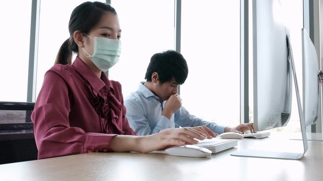 Employee man cough without mask and woman working together look with concern coronavirus(covid-19) outbreak that man put on mask.