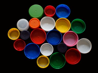 Group of multicolored bottle caps on black background