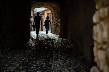 Couple of tourists walking together under a tunnel in Italy