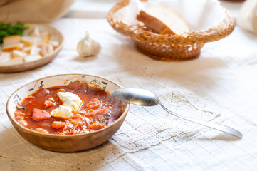 Ukrainian borsch well served with cream, garlic, salo - on white rustic tablecloth