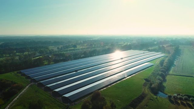 Solar Plant: Rows of Solar Panels Producing Sustainable Energy, Reflection From the Sun, Zooming Out - Friesland, Netherlands / Holland &ndash; 4K Drone Footage