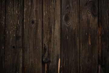 The texture of the Wooden wall a dark brown color with vertical boards in rustic style