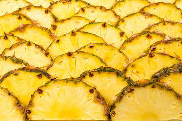 Pineapple juicy yellow slices background. Top view.