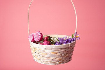 Fototapeta na wymiar Basket of spring flowers isolated on pink background