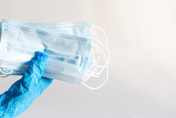 Hand in medical glove is showing protective mask at black background. Coronavirus text on mask. Coronavirus concept. Healthcare concept.