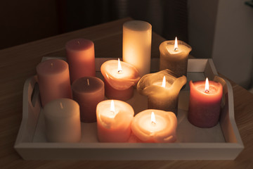 several burning candles on a tray