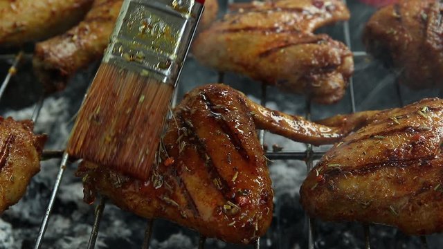 Grilled chicken legs wings barbecue griller cooking process Grease with marinade