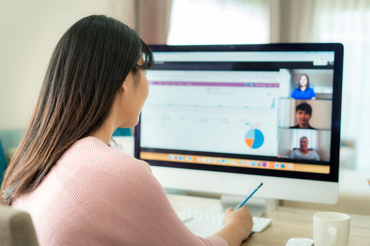 Asian business woman talking to her colleagues about plan in video conference. Multiethnic business team using computer for a online meeting in video call. Group of people smart working from home..