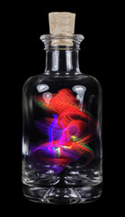 Kleine durchsichtige Glasflasche mit Flaschengeist vor schwarzem Hintergrund.