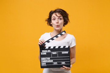 Amazed young brunette woman girl in white t-shirt posing isolated on yellow orange wall background...
