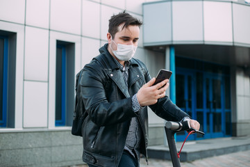 Concept of coronavirus quarantine, man with medical face mask using the phone to search for news. Air pollution