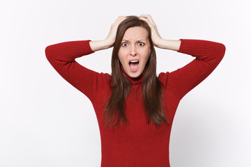 Shocked bewildered young brunette woman girl in casual red clothes posing isolated on white background in studio. People lifestyle concept. Mock up copy space. Put hands on head, keeping mouth open.