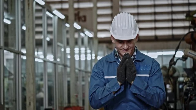 Engineer factory man greeted with hands to pay respect With a smile of happy at work. Safety helmet help to safe during work of mechanic. Non-contact greeting help prevent coronavirus (COVID-19).