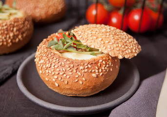 Egg served in bread bowl. Breakfast baked eggs in bread bowls with the fresh herbs.
