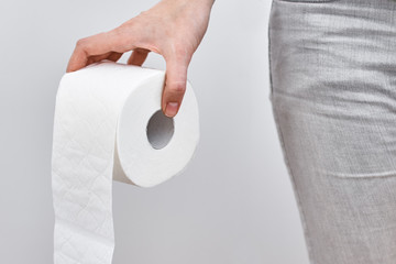 Woman hand hold a toilet paper roll, close up. Hygiene concept