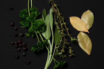 Sage, parsley, thyme, laurel, juniper, herbs on a black background. minimalistic, modern, with copy space