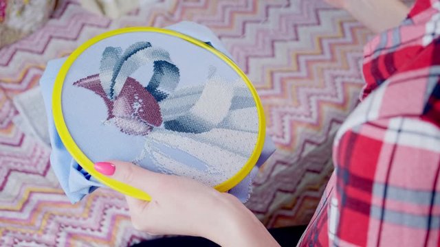 The woman is embroidering on hoop a picture. Home Crafts 4k